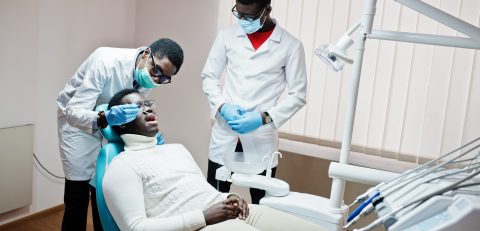 African american man patient in dental chair. Dentist office and African american man patient in dental chair. Dentist office and doctor practice concept. Professional dentist helping his patient at dentistry medical.