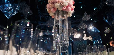 Tall centrepiece made of pink flowers and crystal chains stands Tall centrepiece made of pink flowers and crystal chains stands on dinner table